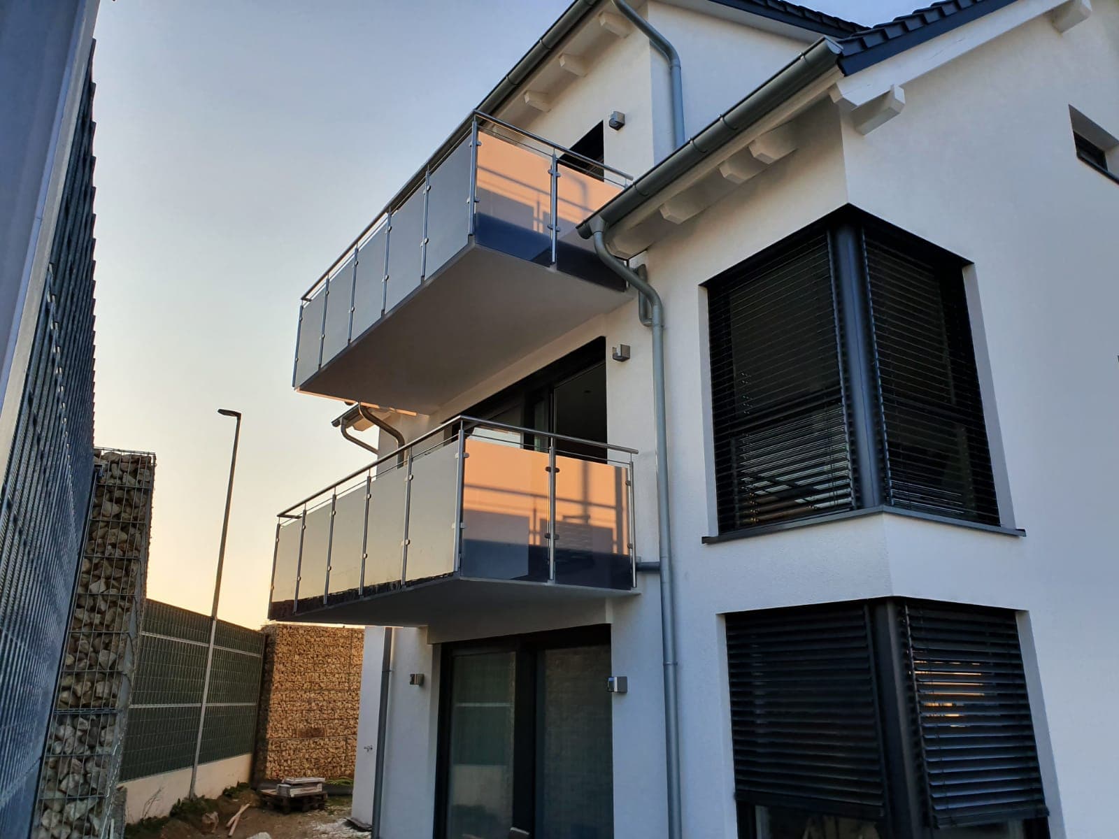 Zwei Balkone mit Edelstahlgeländer und satinierter Glasfüllung an einem Neubau